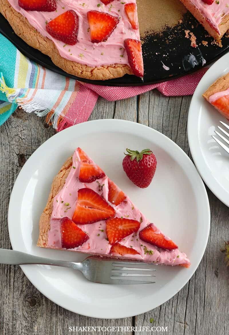 Strawberry Dessert Pizza from a Cake Mix is an easy breezy Summer dessert made with a strawberry cookie crust, strawberry frosting, fresh sliced strawberries and a sprinkle of lime zest!