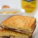 grilled cheese and soup with sliced apple son white plate