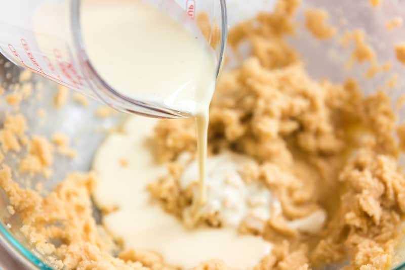 pouring eggnog into cookie dough