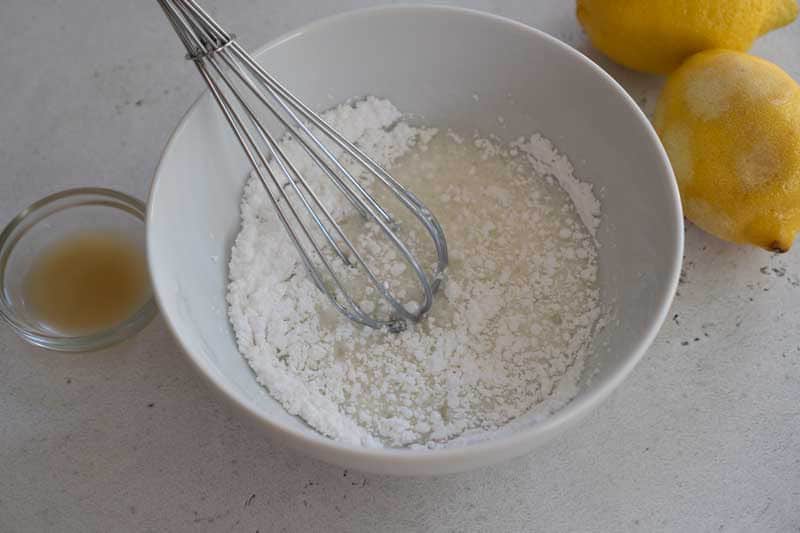 mixing lemon glaze in white bowl
