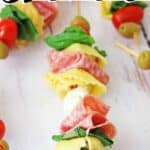 anitpasto kabob skewer on white table with overlay text reading antipasto skewers