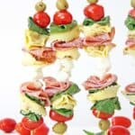 3 anitpasto skewers standing up on wood table