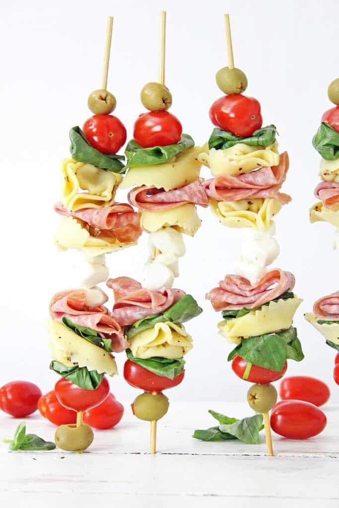 3 anitpasto skewers standing up on wood table