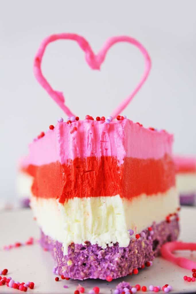 layered valentine's no bake cheesecake with bite taken out
