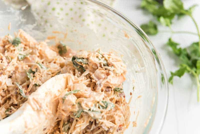 stirring shrimp and cheese with mayo for shrimp nachos