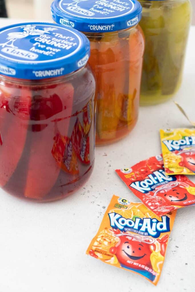 three jars of kool aid pickles and kool aid packets