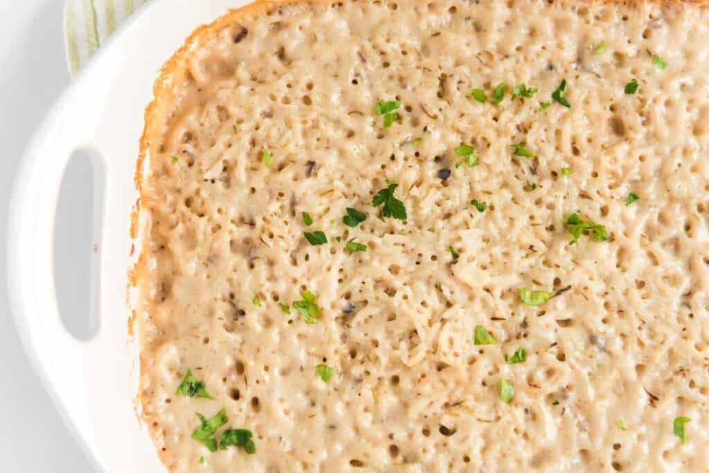 baked rice and pork chops in white casserole dish