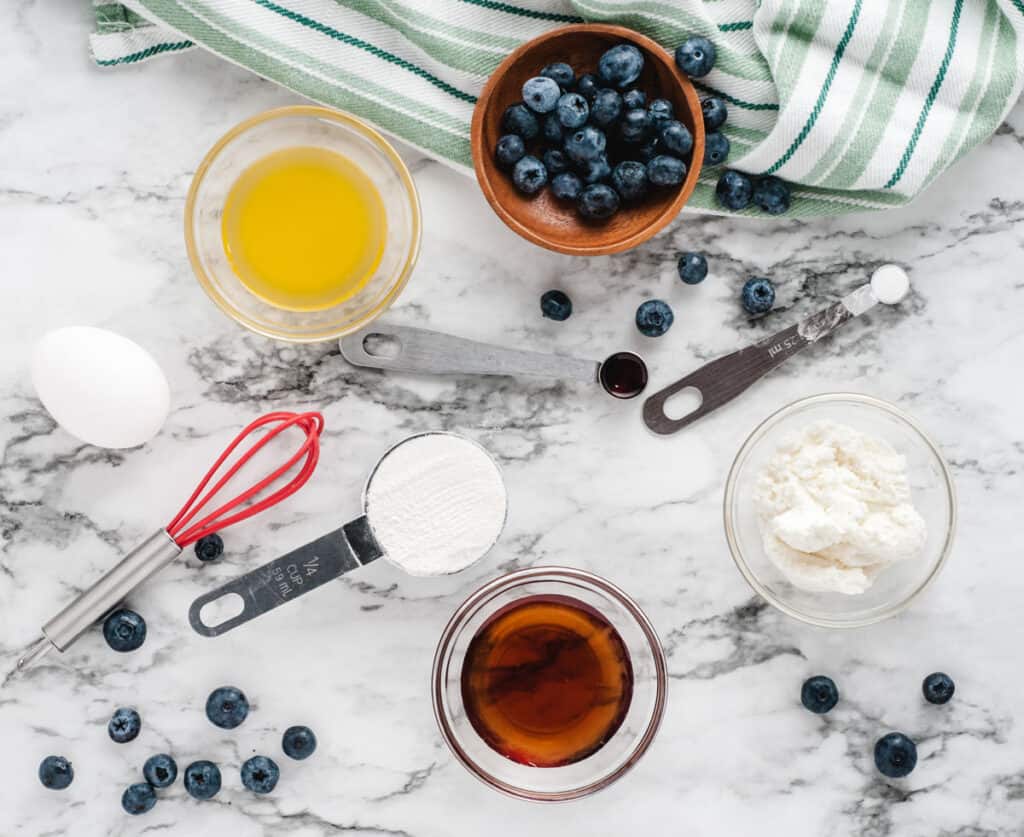 ingredients for blueberry mug cake on marble countertop