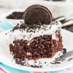 oreo poke cake with oreo cookie on top on white plate