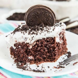 oreo poke cake with oreo cookie on top on white plate