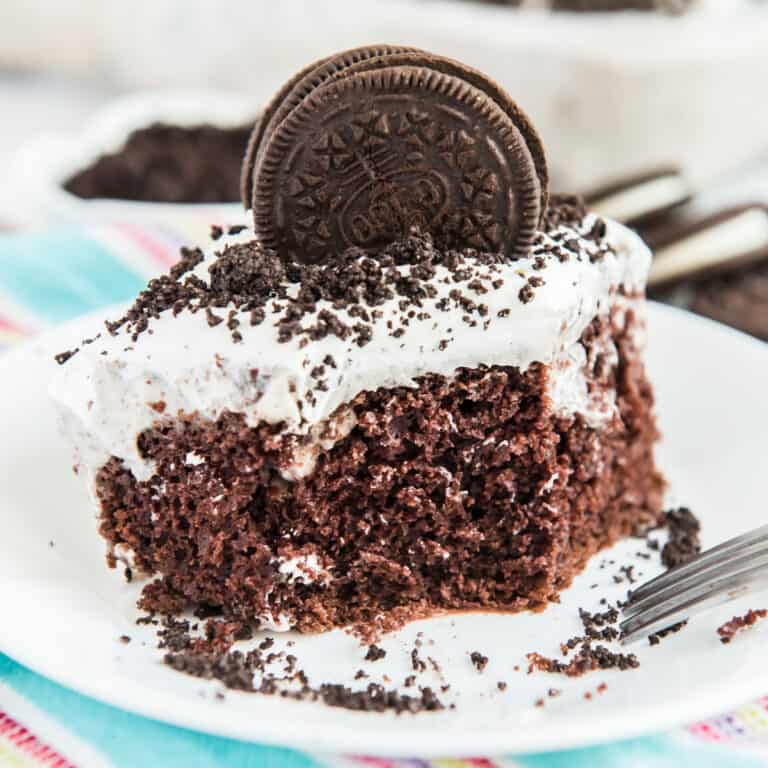 oreo poke cake with oreo cookie on top on white plate