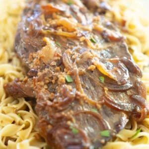 slow cooker london broil over egg noodles with onions and gravy