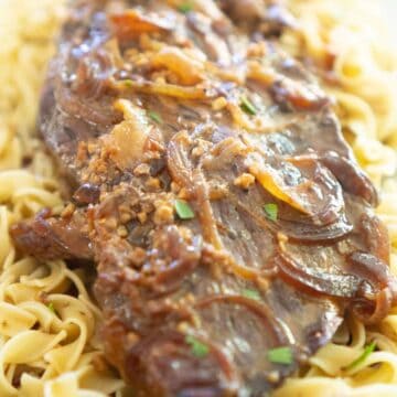 slow cooker london broil over egg noodles with onions and gravy