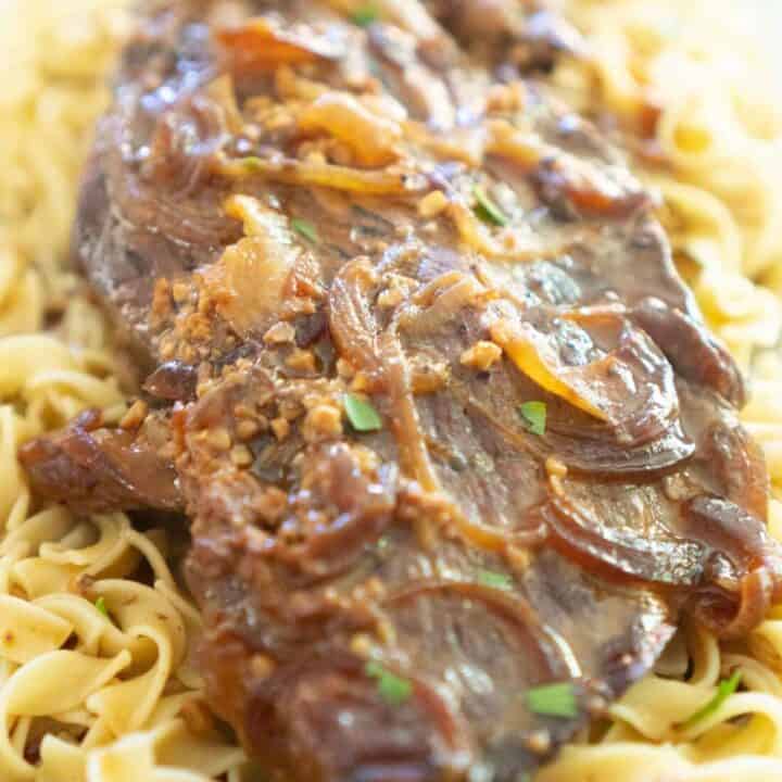 slow cooker london broil over egg noodles with onions and gravy
