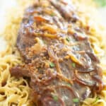 slow cooker london broil over egg noodles with onions and gravy
