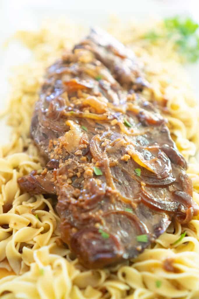 slow cooker london broil over egg noodles with onions and gravy