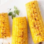 grilled corn on white plate with text reading grilled corn