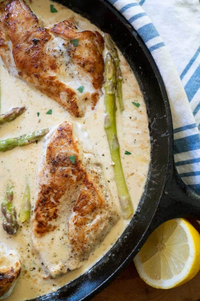 cast iron skiller with chicken and asparagus in a cream sauce