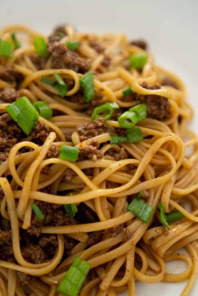 Mongolian noodles on white plate with green onion