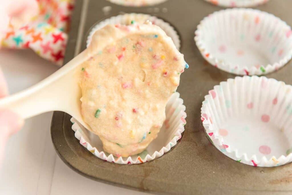 spooning batter into muffin tin