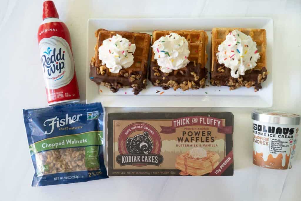 waffle ice cream sandwiches on white platter with ingredients surrounding
