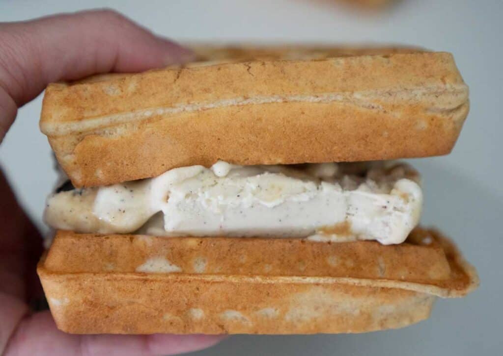 hand holding waffle ice cream sandwich