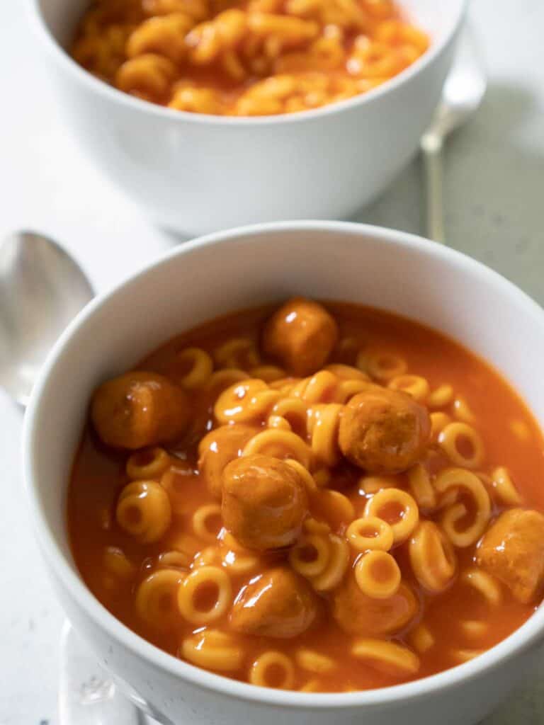 close view of spaghetti-os with meatballs in white bowls