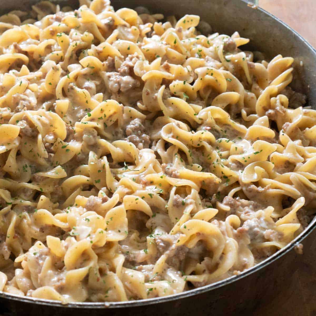 close up of creamy sausage pasta in pan