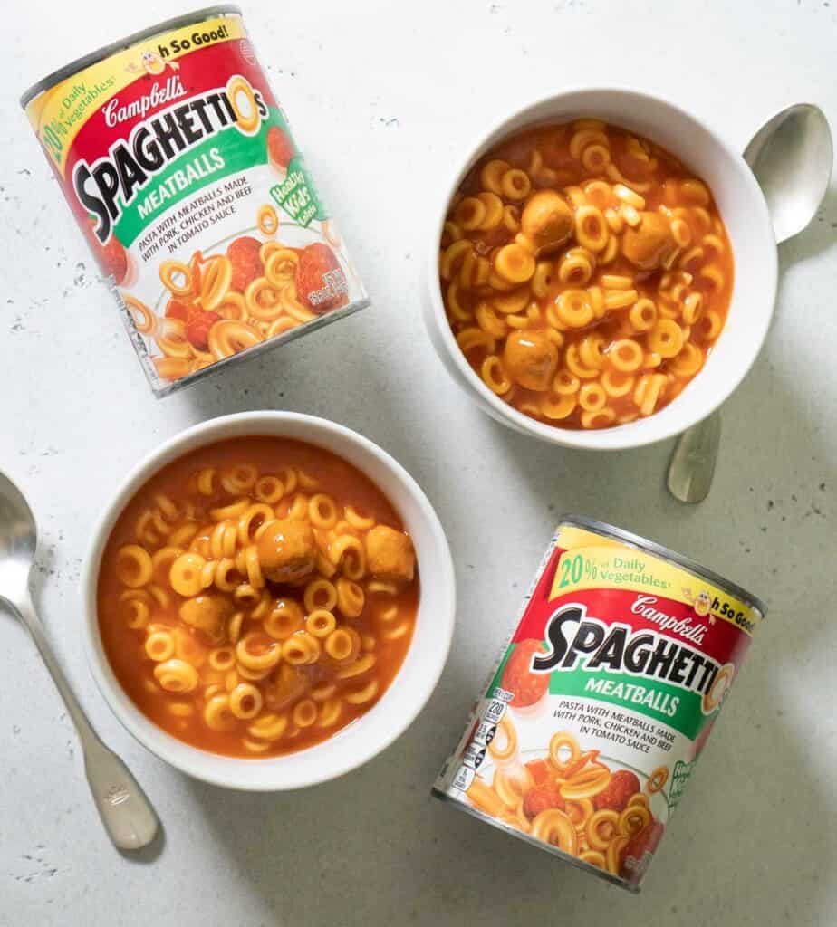 overhead view od spaghettis-os cans with spaghetti-os in white bowls