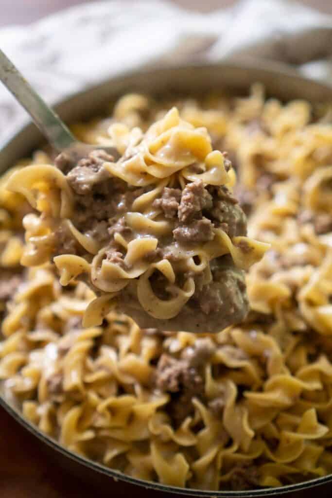 ground beef stroganoff in spoon held over pan