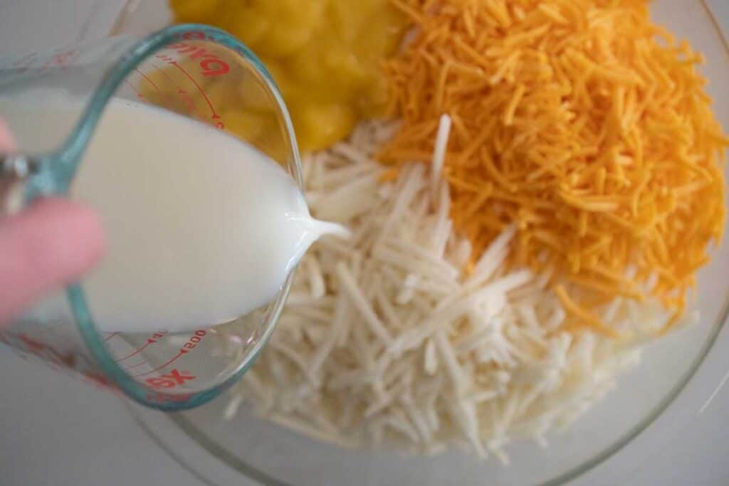 milk pouring over hash browns and cheese