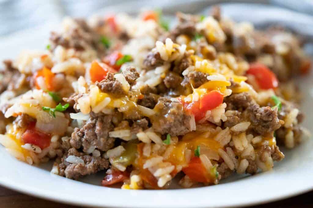 beef and rice with cheese on white plate