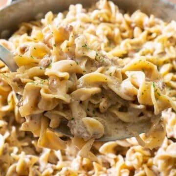 sausage pasta in spoon over pan