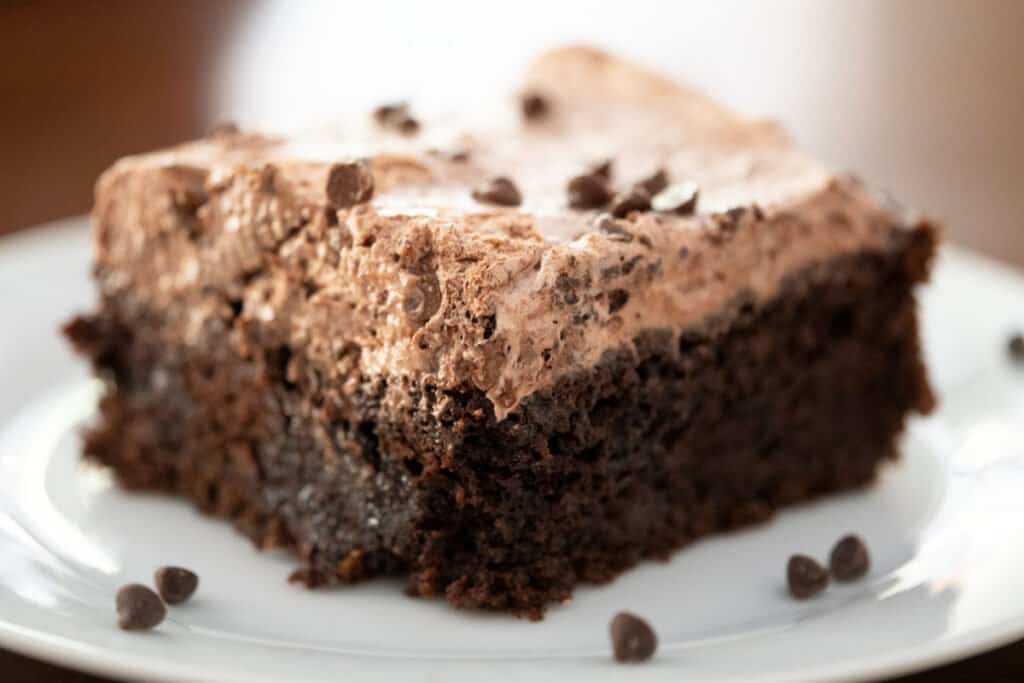 slice of chocolate poke cake on white plate