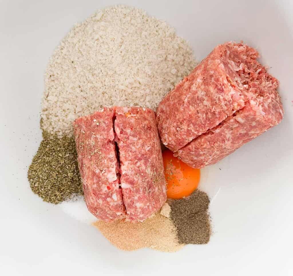 sausage roll filling ingredients in white bowl before mixing