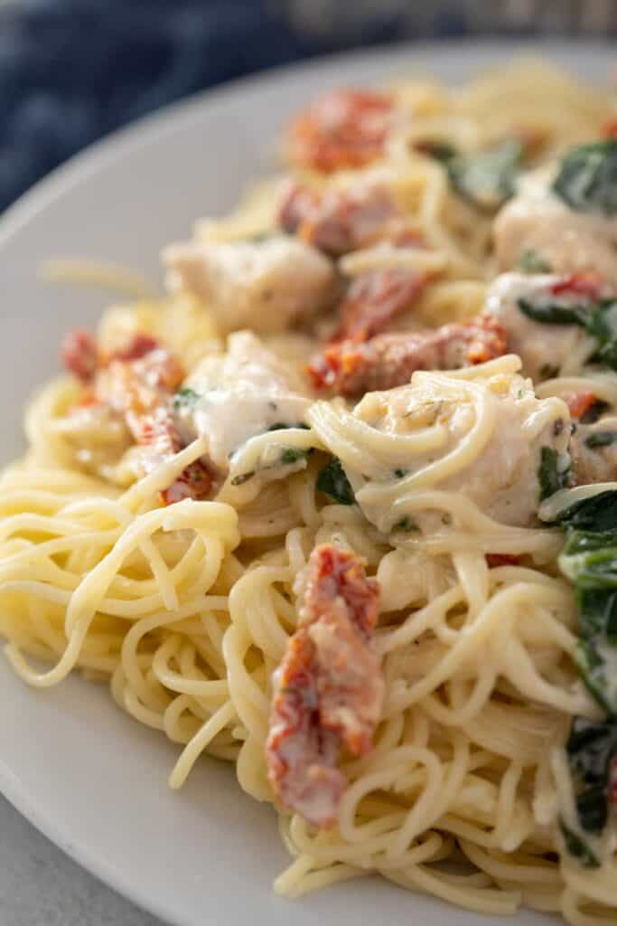 creamy Tuscan chicken pasta on white plate