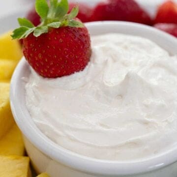 close up of fruit dip in white bowl with strawberry