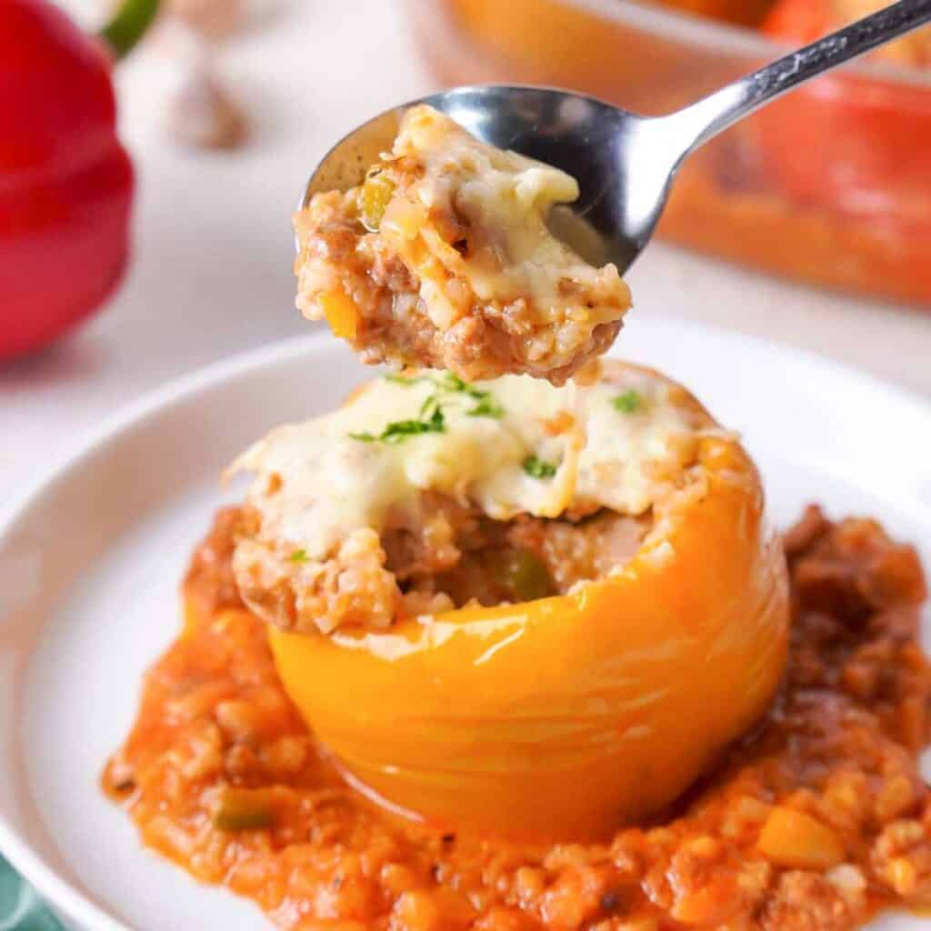 spoon scooping filling from slow cooker stuffed pepper