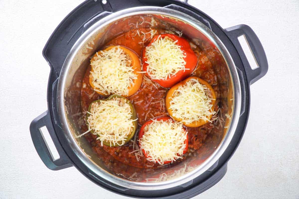 slow cooker with cheese topped stuffed peppers