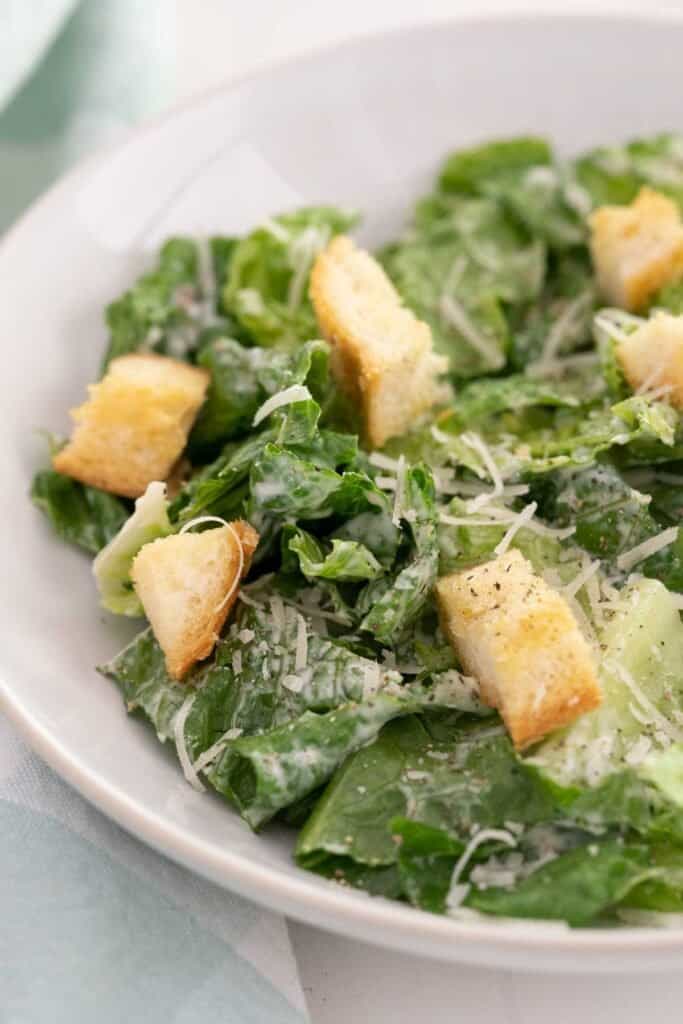 white bowl with caesar salad and croutons