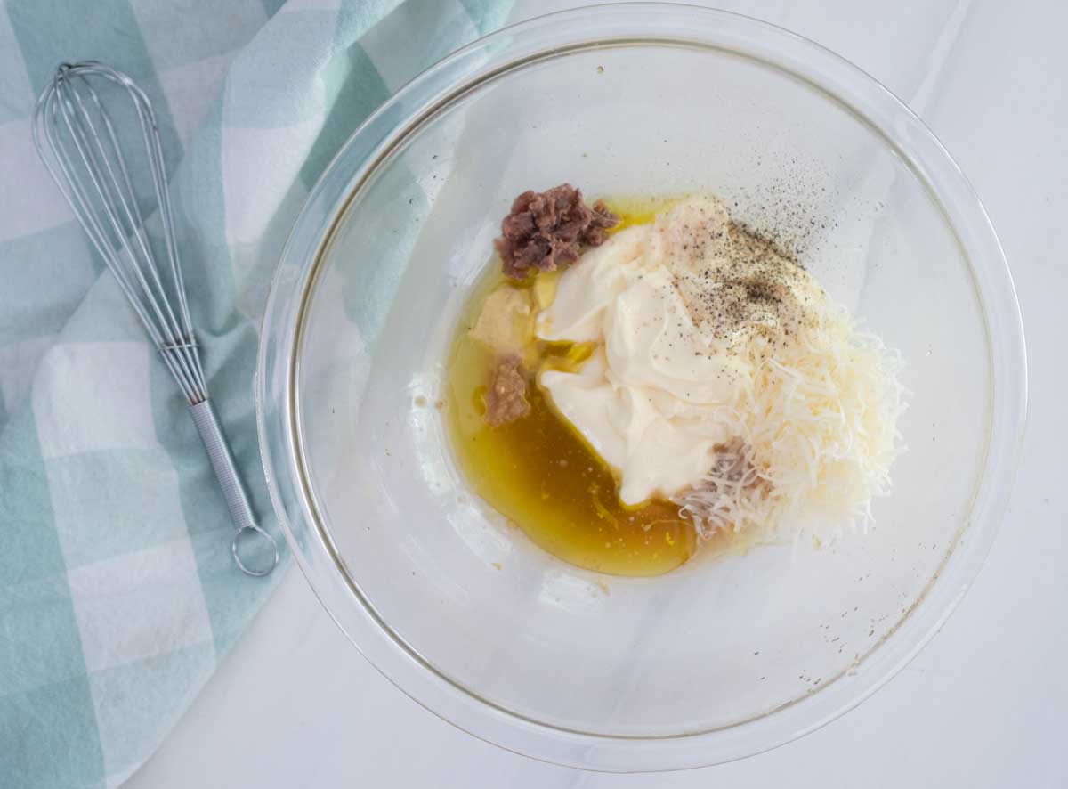 caesar dressing ingredients in clear glass bowl