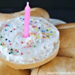 bagel with birthday cake cream cheese on it and a candle