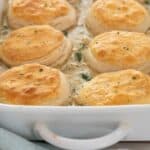 chicken pot pie casserole with biscuits in white casserole dish