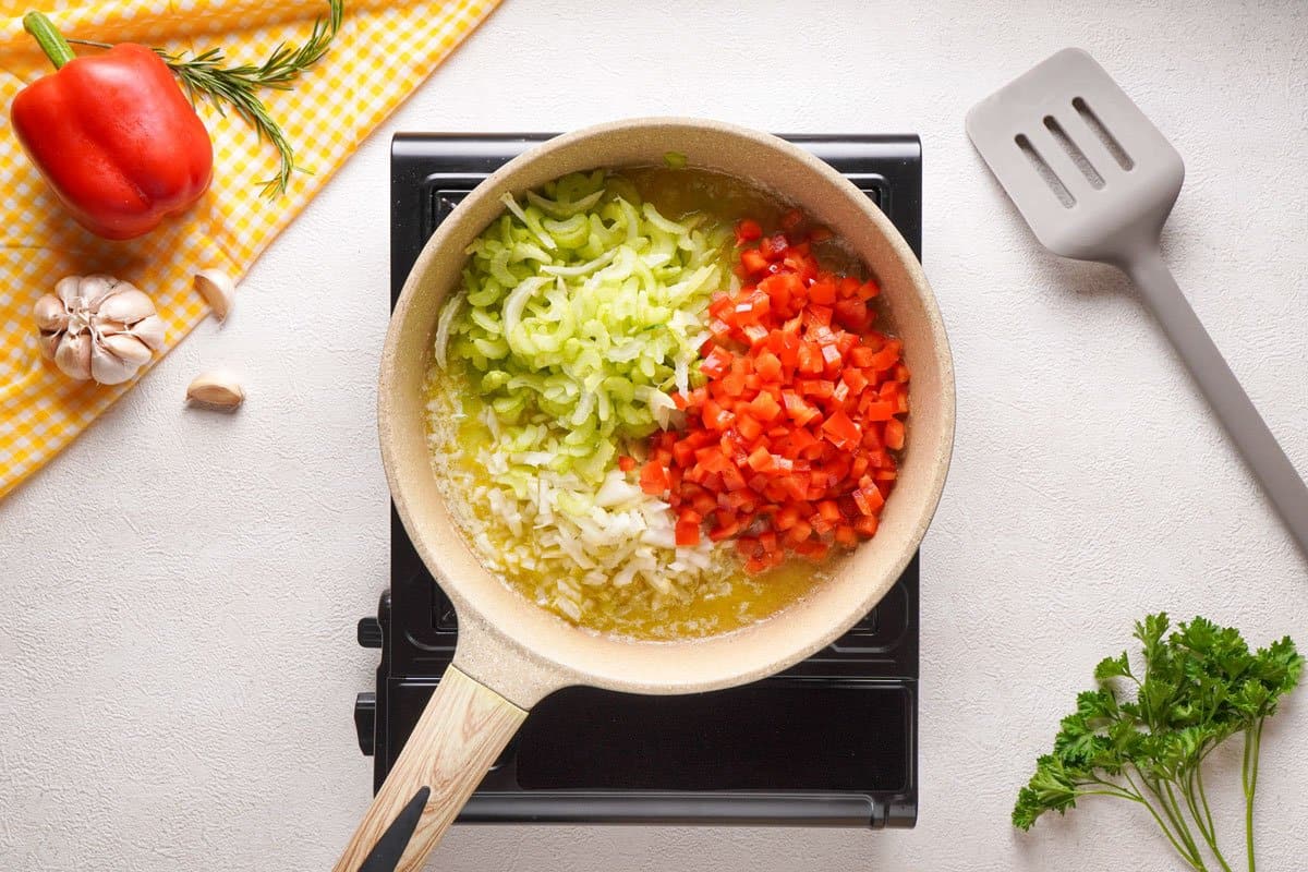 cooking onion, celery and bell pepper in pan
