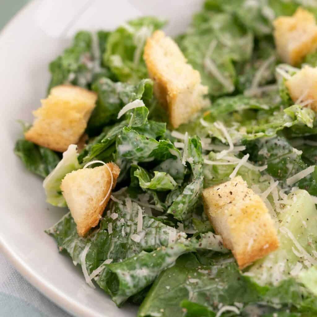 caesar salad in white bowl