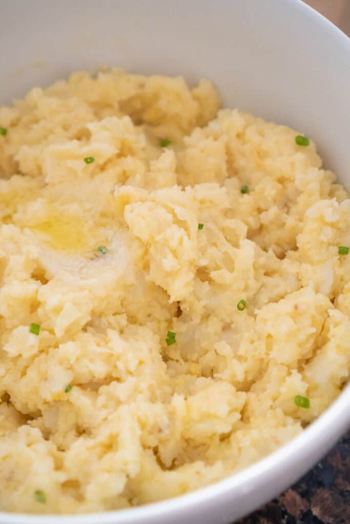 cheesy garlic mashed potatoes in white bowl