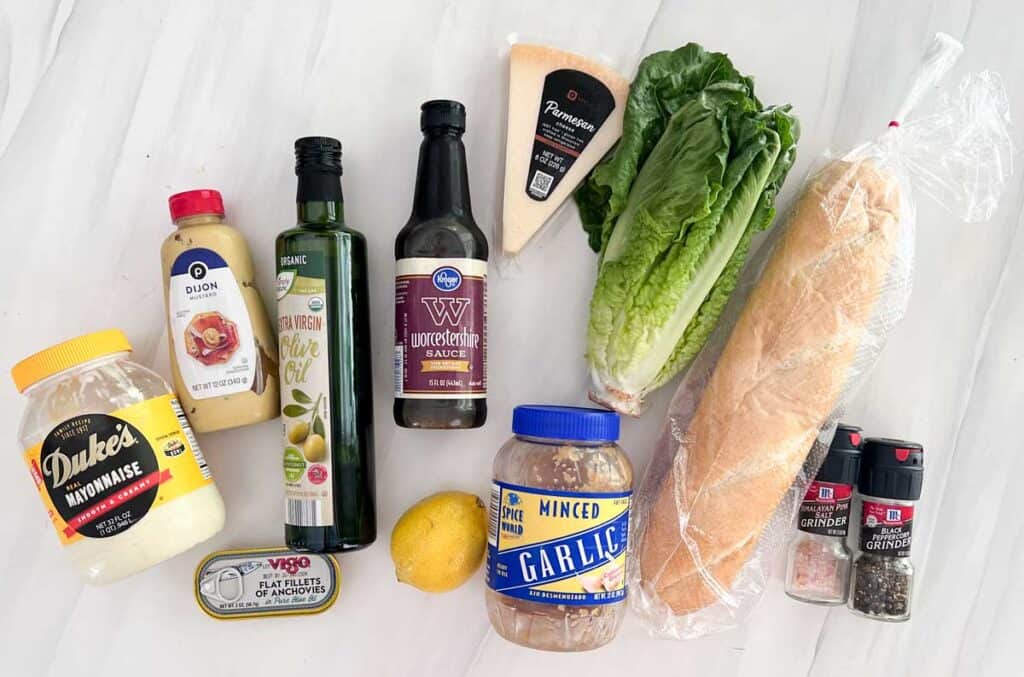 ingredients for homemade caesar salad on marble countertop