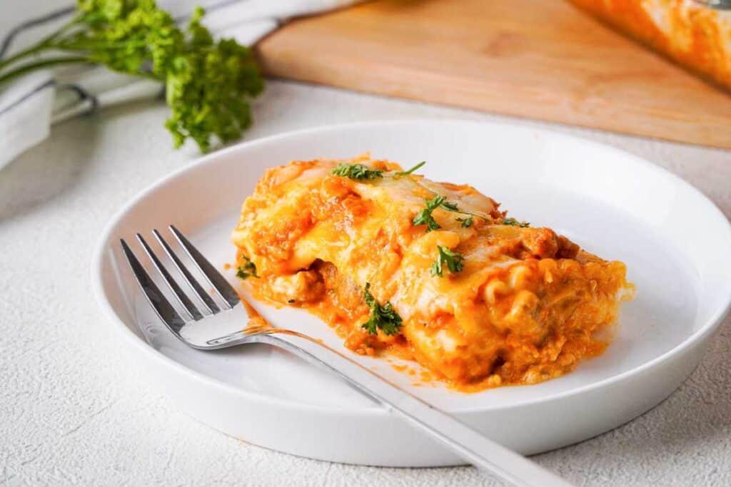 lasagna roll up on white plate with fork