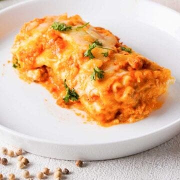 single lasagna roll up on white plate