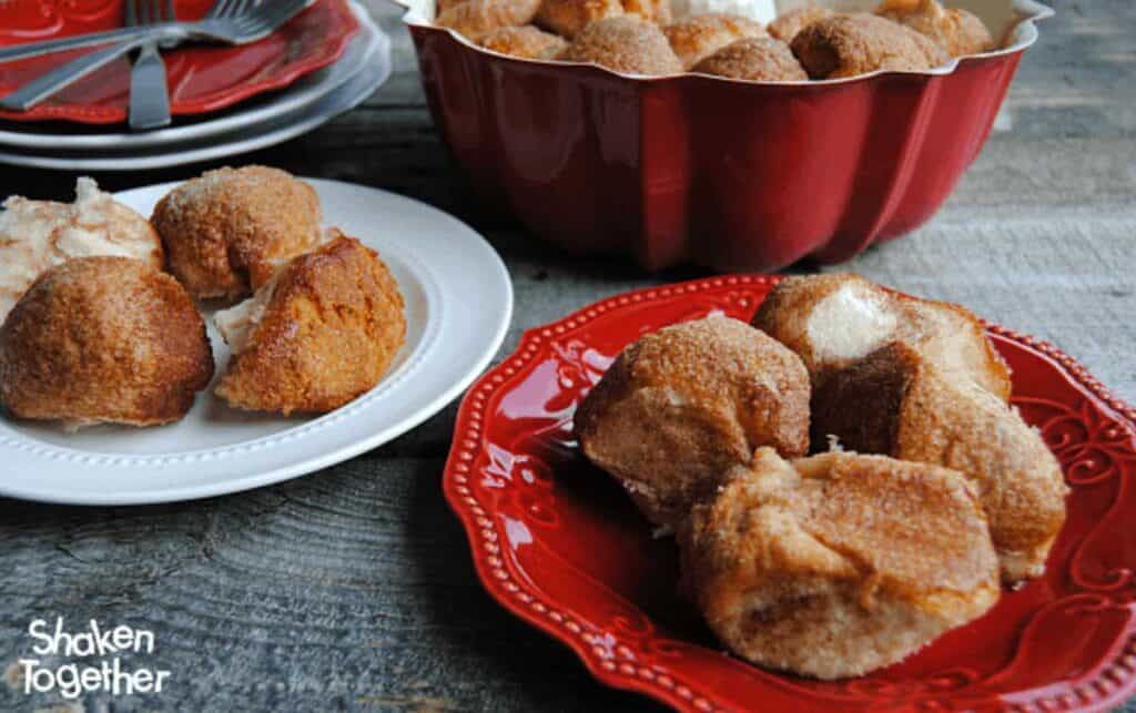 monkey bread bites on red and white plates with bundt pan in background